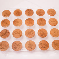 Matching game with stylized woodland animals laser burned on wooden coins being displayed on an acrylic stand. 